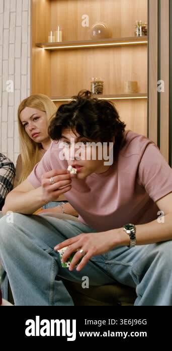 Young Caucasian man and woman seated on a couch, actively conversing in ...