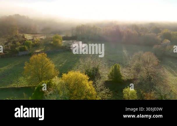 Scenic aerial footage flying over a misty rural landscape with green ...