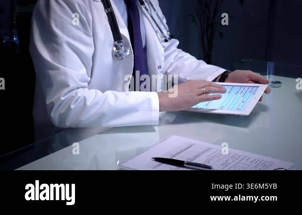 Doctor hands typing and reviewing patient medical information on a ...