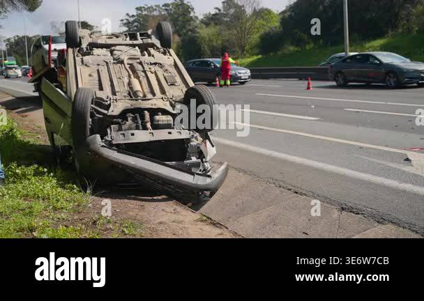 Car lying upside down after an accident on the highway. Policeman ...