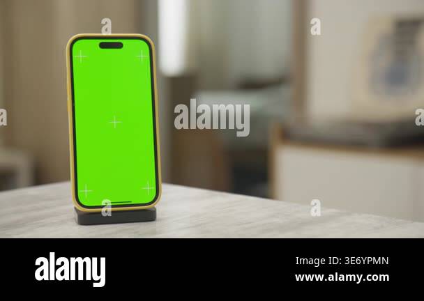 Vertical smartphone with bright green chroma key display on a stand ...
