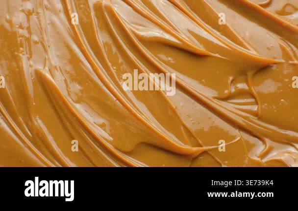 Rotating dulce de leche background with glossy caramel waves Stock ...