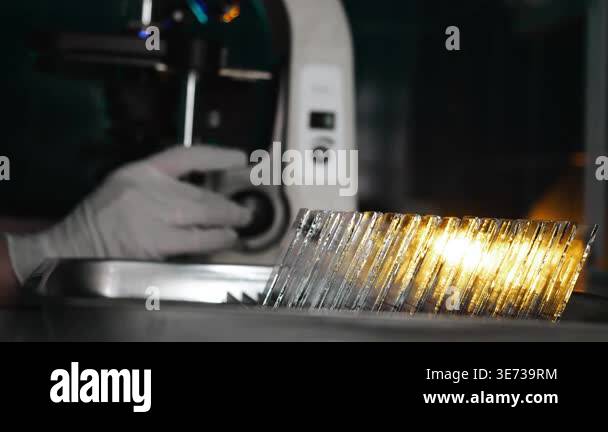 Glass microscope slides illuminated in laboratory with scientist using ...