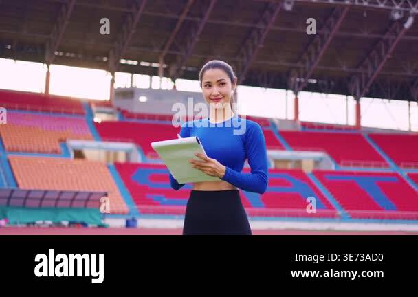 Smiling woman holding clipboard at stadium Stock Video Footage - Alamy