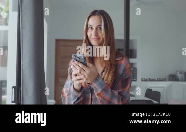 Happy user smiling woman holding smartphone looking at camera in modern ...
