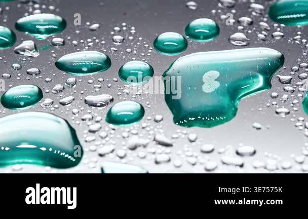 Close view of water droplets on shiny surface reflecting light in a ...