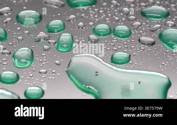 Close view of water droplets on shiny surface reflecting light in a ...