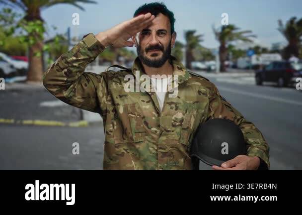 Military man with beard saluting outdoors in camo uniform holding ...