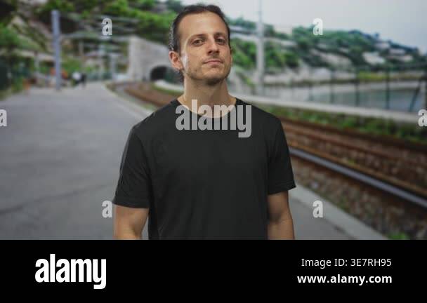 Young hispanic man standing with relaxed arms looking at camera on ...