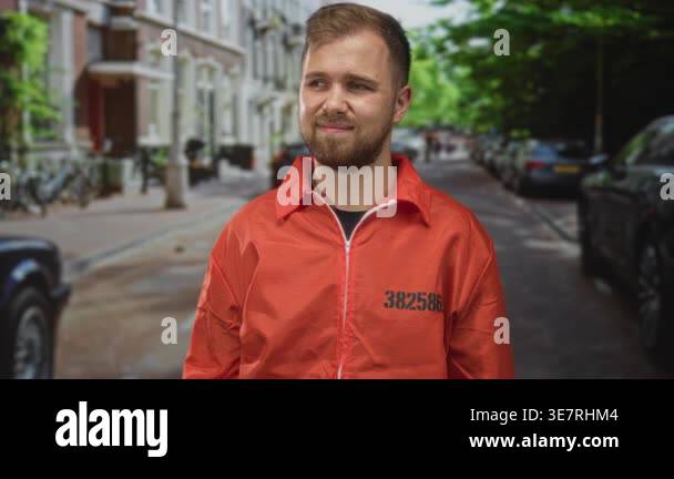 Man prisoner with beard smiling and looking aside on a city street in ...