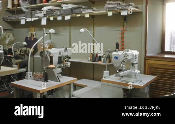 Blurred tailoring shop interior with shallow focus on industrial sewing ...