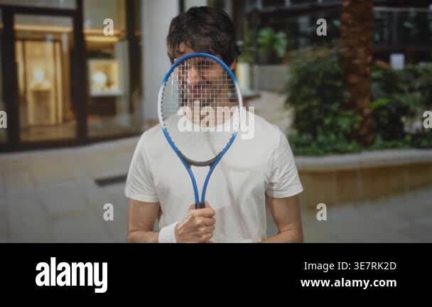 Smiling man holding racket and hand gripping handle wearing white ...