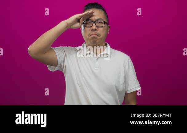 Man saluting with hand to forehead wearing white polo shirt in magenta ...