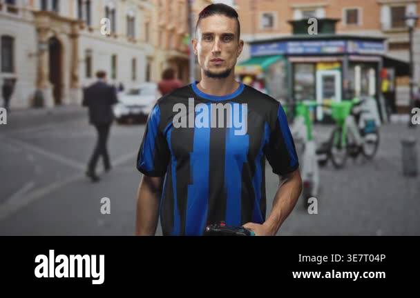 Man in blue and black soccer jersey saluting with right hand on ...