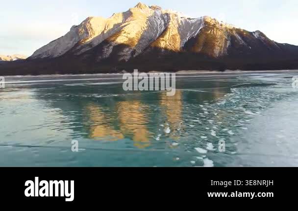Aerial fly through over frozen Abraham Lake in Alberta with dramatic ...