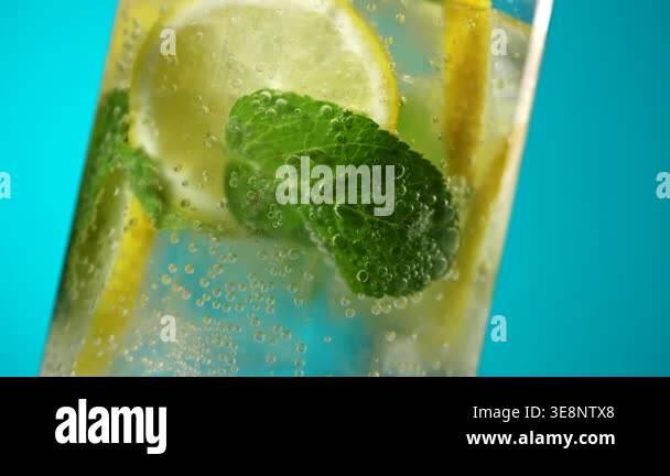 Fresh sparkling lemonade with lemon slices mint leaves and ice cubes in ...