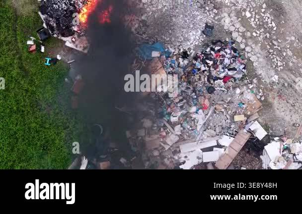 Aerial view drone footage showing outdoor rubbish pile burning with ...