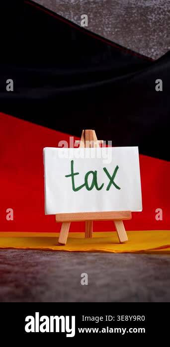 Paper note with words TAX on National symbol of Germany. German wave ...