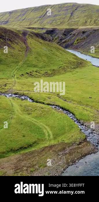 Aerial drone view of a river winding through a narrow canyon surrounded ...