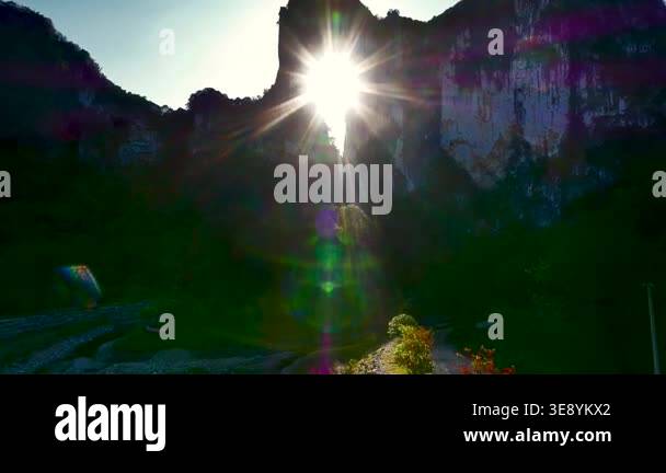 A stunning view of the bright sun shining through a natural hole in a ...