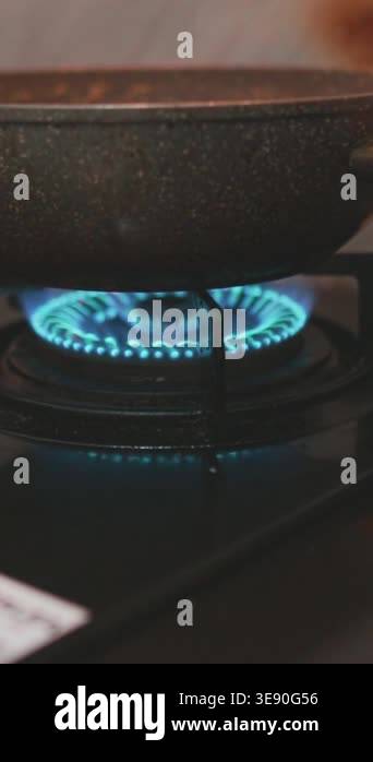 A macro, close-up view of the consistent and hot blue flame from a gas ...