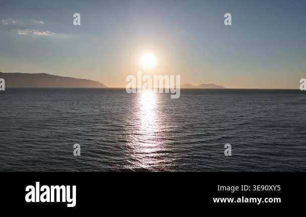 Golden sunset over calm sea with distant islands aerial drone view ...