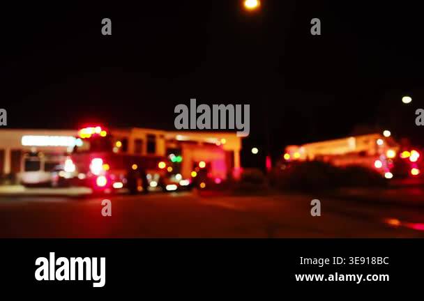 Fire trucks and emergency vehicles with flashing lights responding to a ...