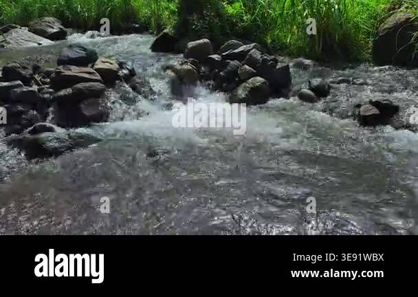 A dynamic and refreshing close-up shot of clear river water rapidly ...