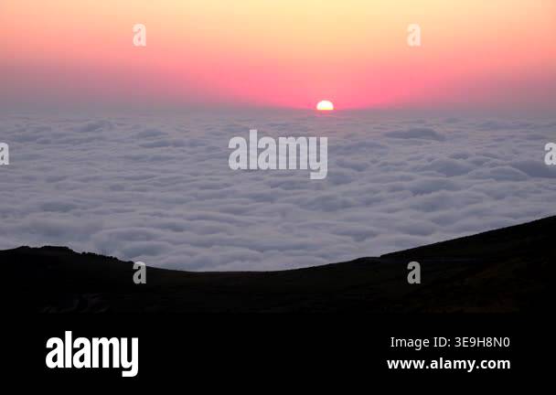 Sunrise above sea clouds from mountain summit, glowing sun over mist ...