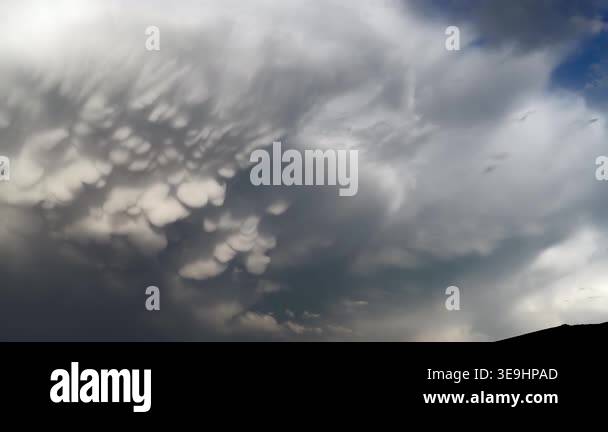 Panoramic view of mammatus clouds forming in blue sky, dramatic storm ...
