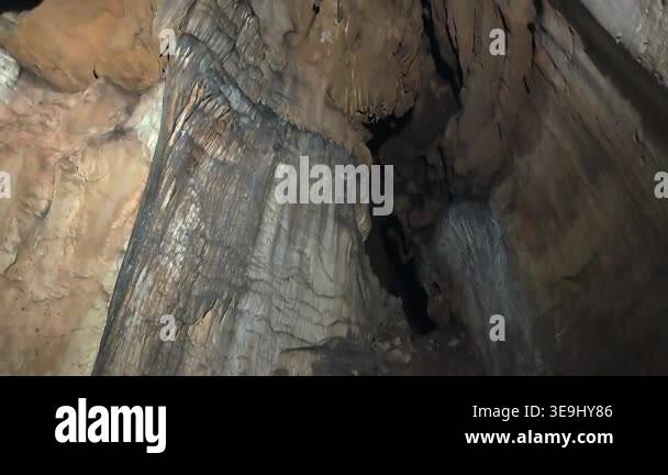 Tilt up view of natural untouched cave wall rising toward dramatic ...