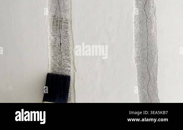 Filling cracks with liquid primer. Repairs in a prefabricated apartment ...