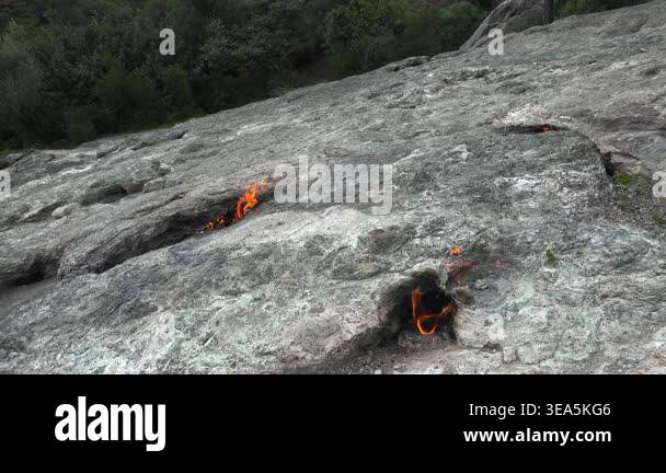 Flame of burning methane gas emerging from underground rock crack in ...