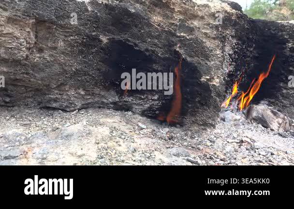 Flame of burning methane gas emerging from underground rock crack in ...
