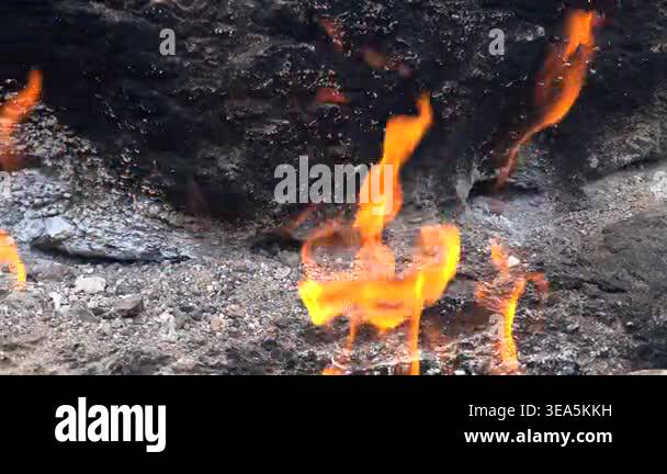 Flame of burning methane gas emerging from underground rock crack in ...