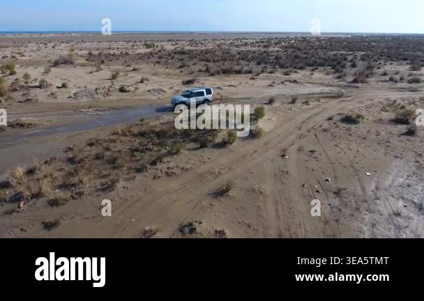 Aerial view off road SUV splashing muddy water while crossing puddle in ...