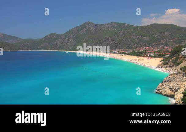 Bright coastal scenery shows clear sea water and broad shoreline ...