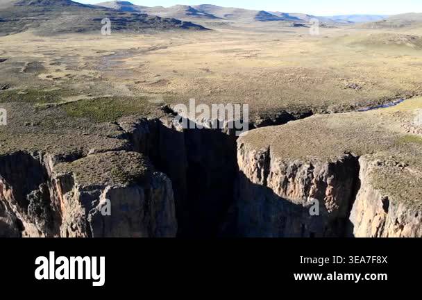 Aerial Shot Deep Shadowed Canyon Fissure Opening, Sheer Cliffs Dropping ...