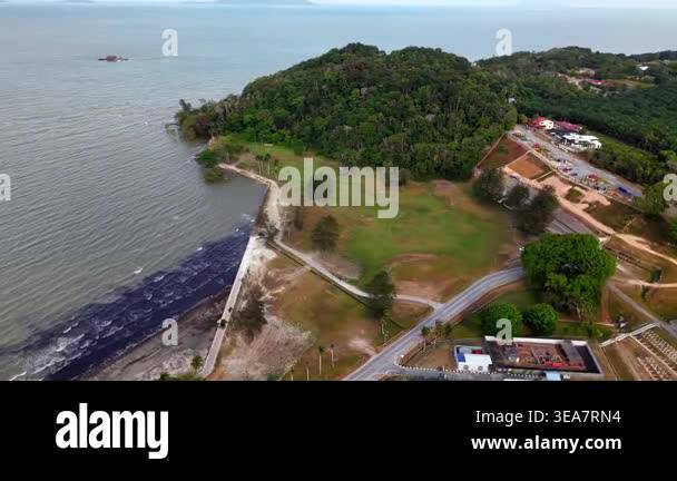 Aerial shot reveals calm ocean waters meeting a sandy shore. Small ...