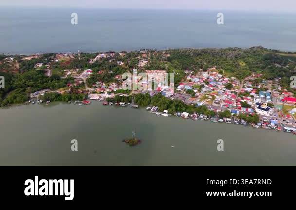Coastal village nestles among green hills and calm waters at Sedili ...