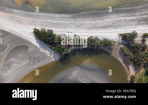 Aerial view of calm river winding through sandy banks. Trees line the ...