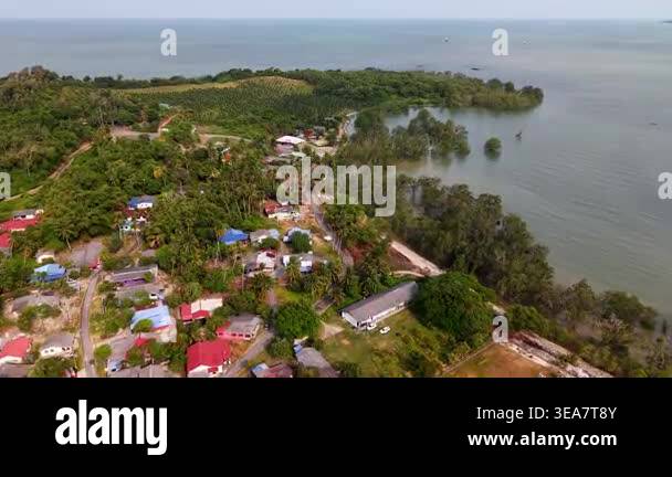 Coastal village nestled amid dense greenery. Vibrant rooftops contrast ...