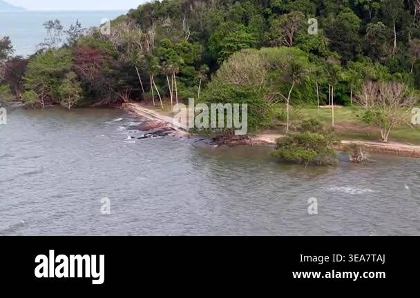 Aerial view reveals a tranquil coastal landscape. Calm waters hug a ...