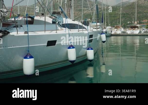 Yacht Hull With White Fenders Reflecting In Calm Marina Water, Ropes ...