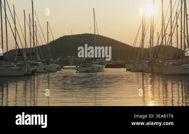 Masts Silhouetted Against Golden Harbor Sunset With Glassy Water ...