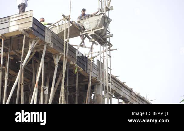 Building Pulling System Construction workers operating a pulley system to lift materials on a ...