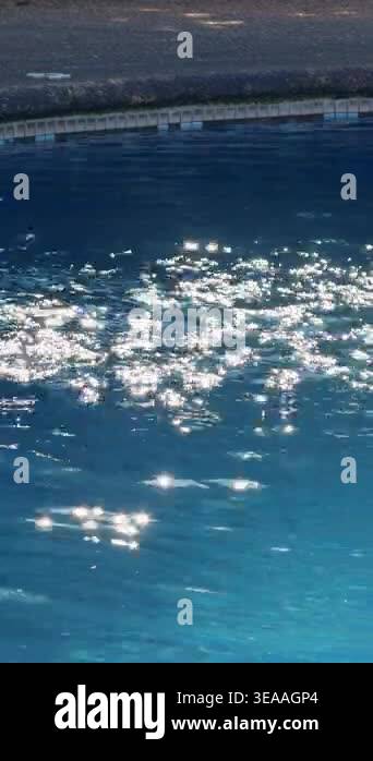 Vertical video. Blue Swimming Pool Water With Bright Sun Sparkles and ...