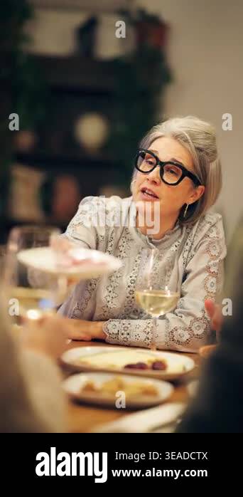 Elegant older woman with grey hair and glasses sharing food with ...
