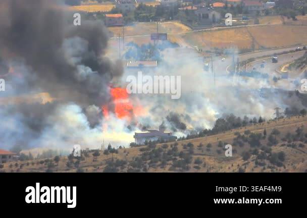 Forest wildfire near suburban homes and highway outside town with heavy ...