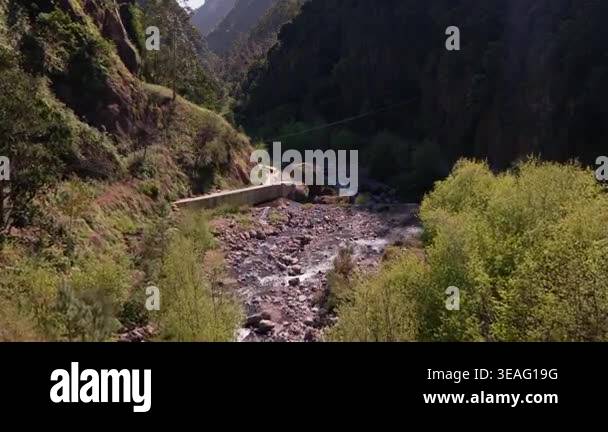 Scenic aerial footage of a deep mountain canyon with a flowing river ...